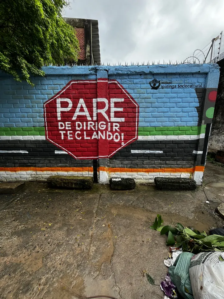 Mural com a frase Pare de dirigir teclando