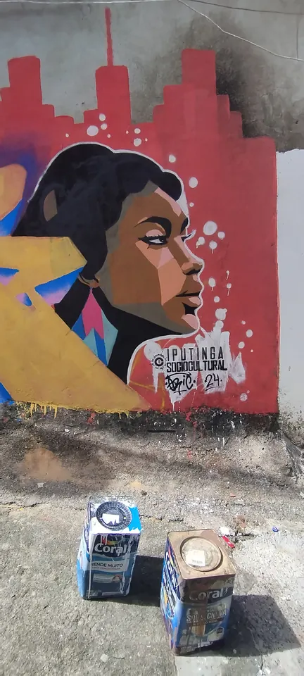 Mural de perfil feminino em frente a uma paisagem urbana