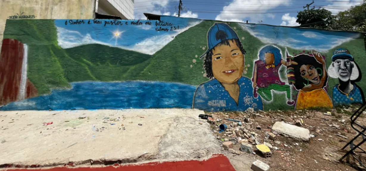 Mural de graffiti com personagens e paisagem pintado em muro da comunidade